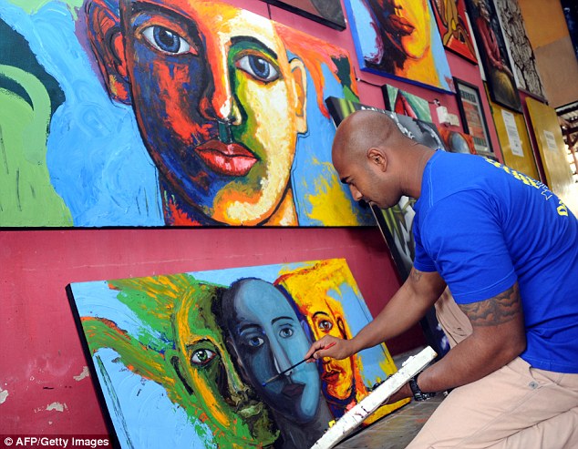 Passionate: Sukumaran took up painting 2010. He now runs an art studio at the jail. Here he is seen painting on a canvas at the prisoners studio